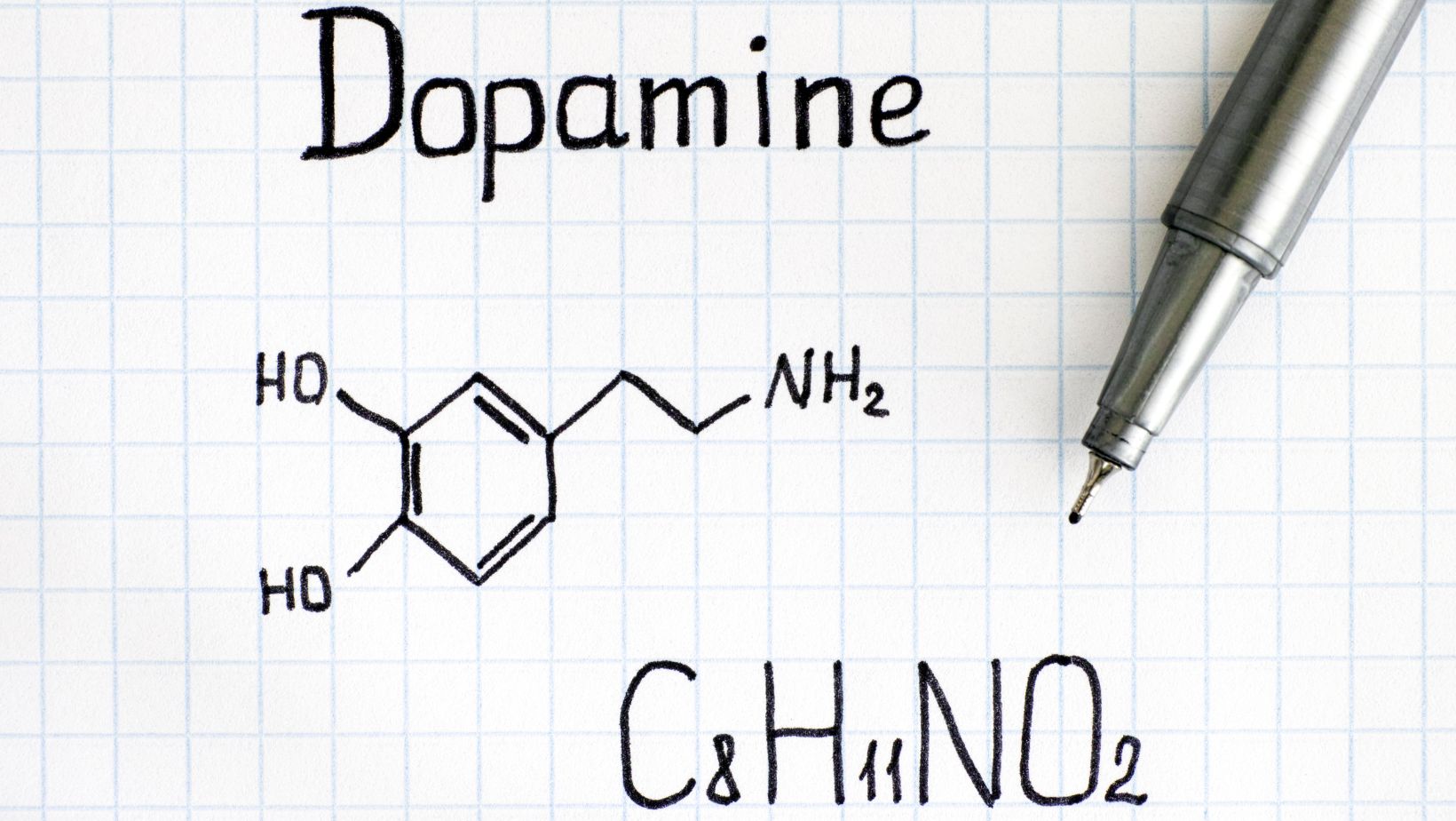 napis dopamina, wzór chemiczny dopaminy narysowane na kartce papieru 