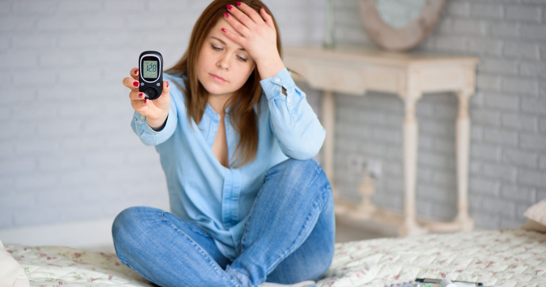 Kobieta z objawami cukrzycy trzymająca glukometr pokazujący poziom cukru we krwi.