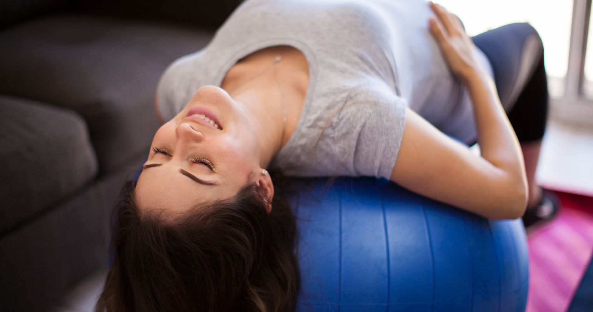 Kobieta w ciąży ćwicząca na piłce gimnastycznej – bezpieczna aktywność fizyczna i relaks w ciąży.