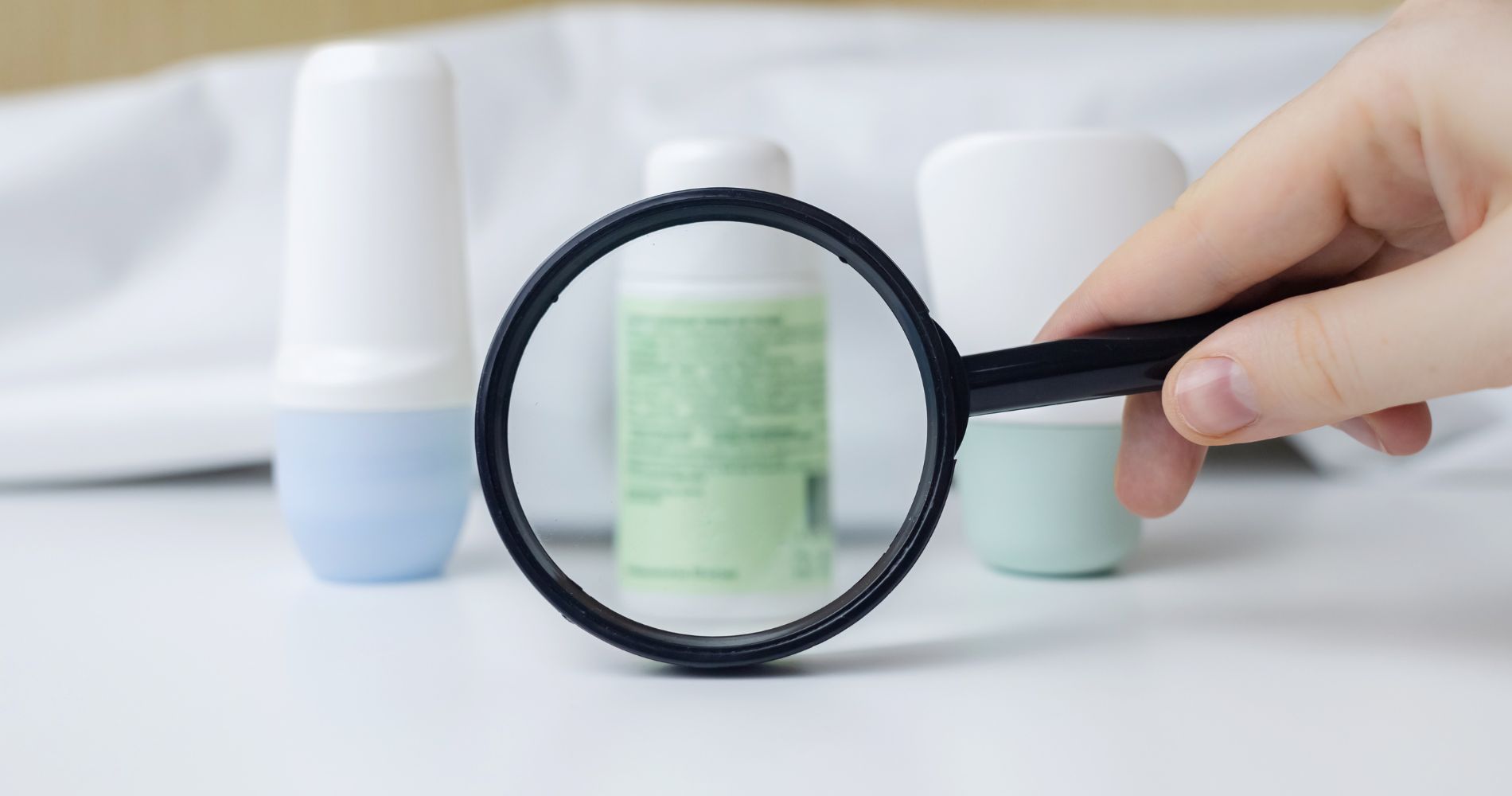 Lupa zbliżająca etykietę kosmetyku – analiza składu produktów pod kątem SLS i SLES.